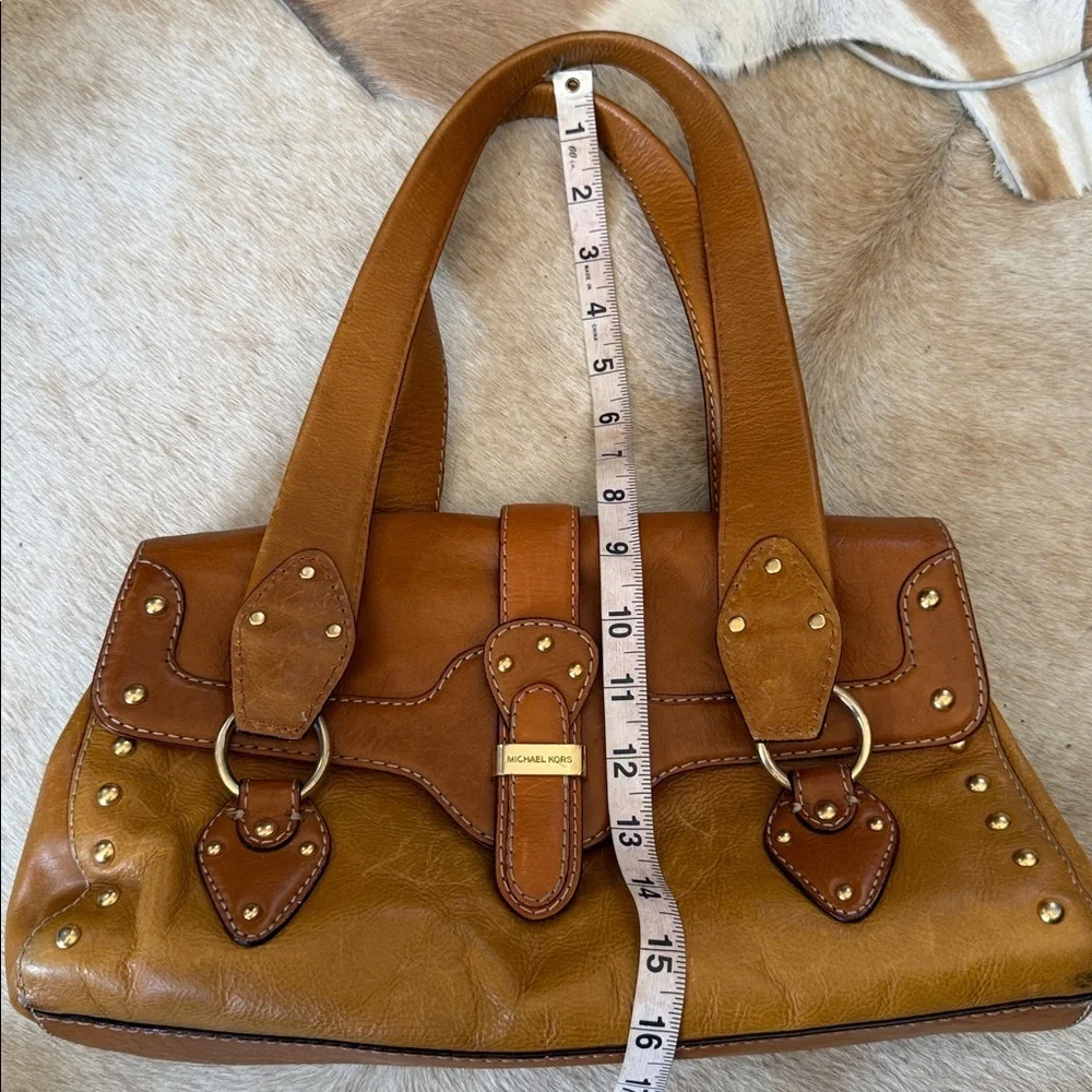 This is a vintage Michael Kors brown leather shoulder bag featuring gold studs